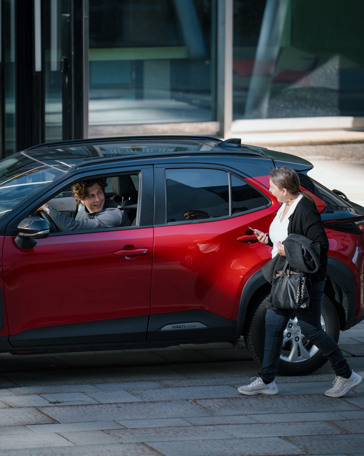 Passasjer møter sjåfør ved rød bil